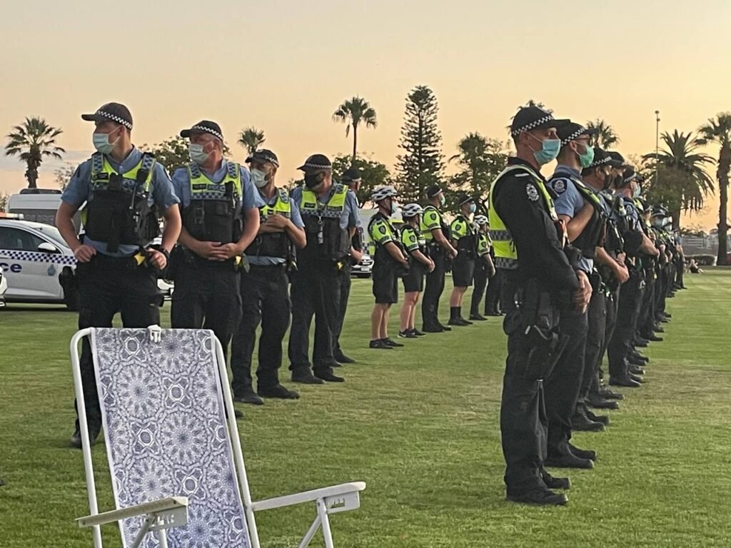 Large number of Police out in force at a public event standing in rows with face masks on